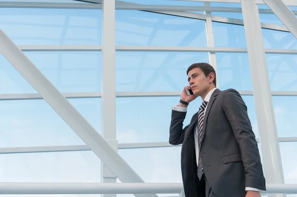 Geschäftsmann nutzt Smartphone am Flughafen. — Stockfoto