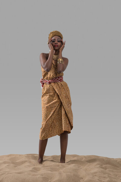 Африканская модная женщина стоит на песке
