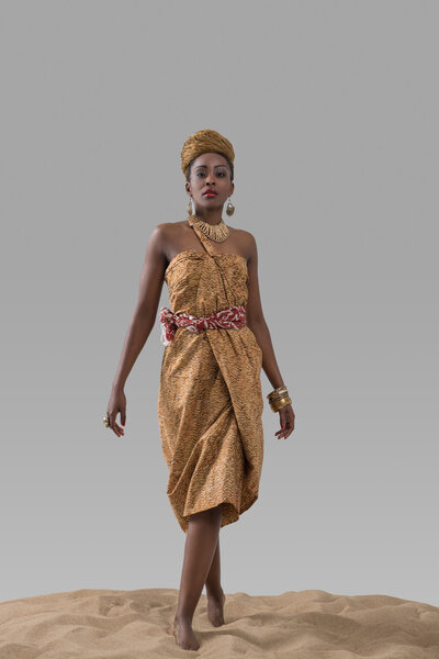 Африканская модная женщина стоит на песке
