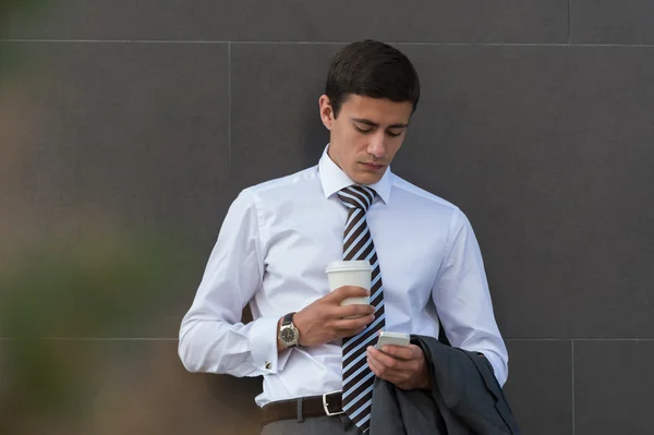 Geschäftsmann mit Kaffee per Handy — Stockfoto