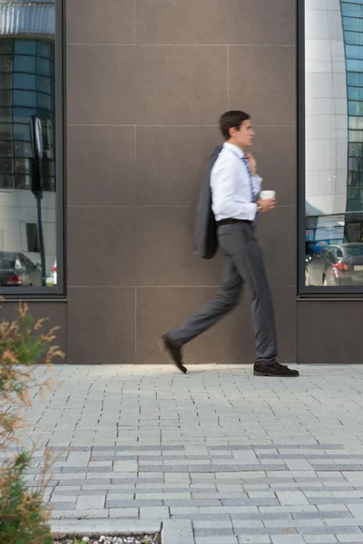 Бизнесмен, идущий в проходе офиса — стоковое фото