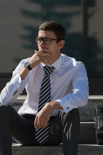 Gut gekleideter Geschäftsmann raucht — Stockfoto