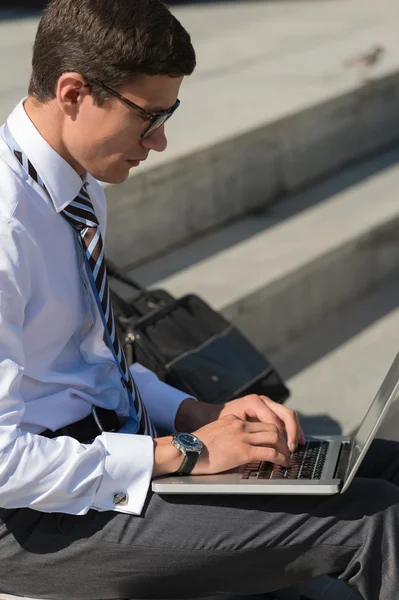 Man met laptop zitting op trappen — Stockfoto