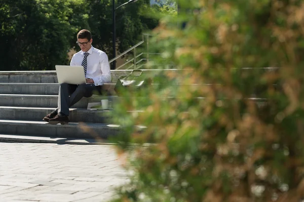 Homem com laptop sentado nas escadas — Fotografia de Stock