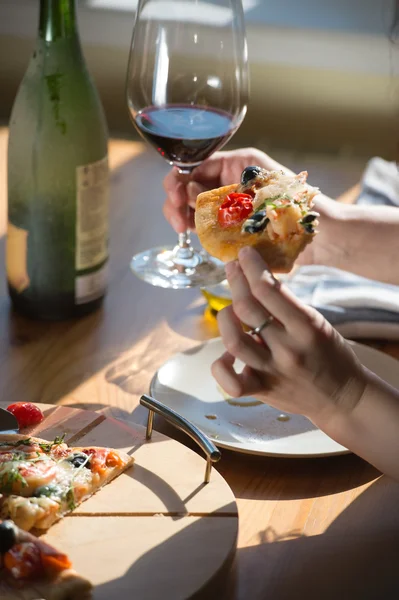 Woman eating  pizza and drinking wine — Stock Photo, Image