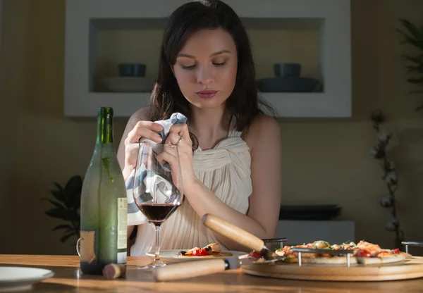 Frau isst Pizza und trinkt Wein — Stockfoto