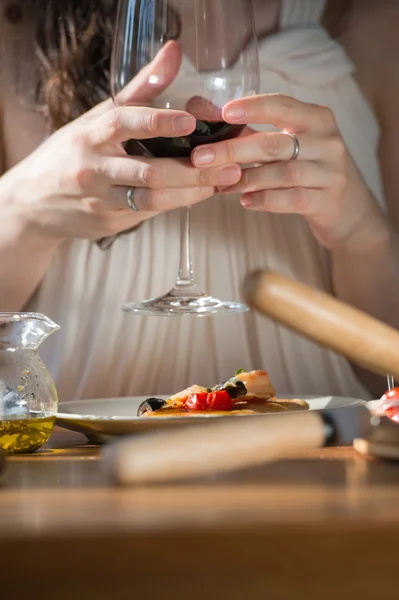 Frau isst Pizza und trinkt Wein — Stockfoto