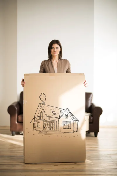 Vrouw met kartonnen doos met huis schilderij. — Stockfoto