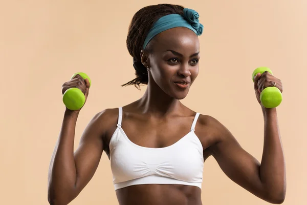 Woman pumping up muscles with dumbbells — Stock Photo, Image