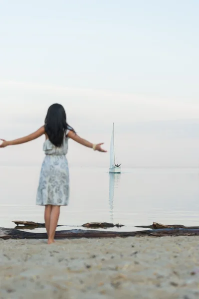 Woman welcoming yacht  at beach — Stock Photo, Image