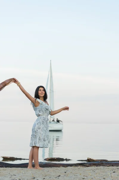 Kvinnan välkomnande yacht på stranden — Stockfoto