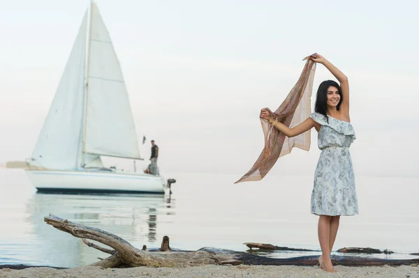 Vrouw gastvrije jacht op strand — Stockfoto