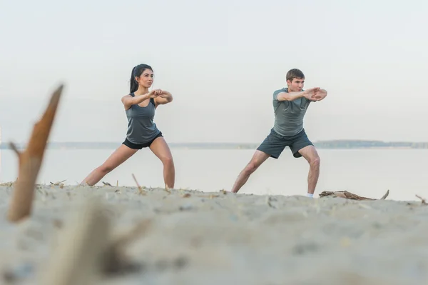 Pareja haciendo ejercicios de estiramiento de yoga —  Fotos de Stock