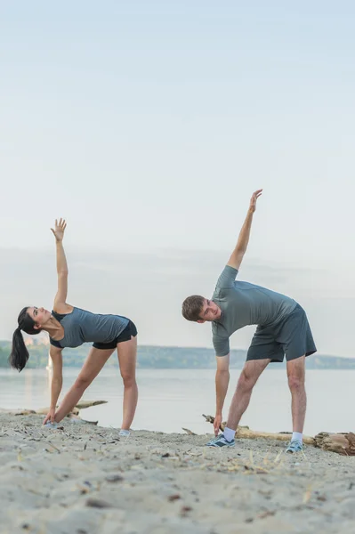 Couple making stretching yoga exercises — Stock Photo, Image