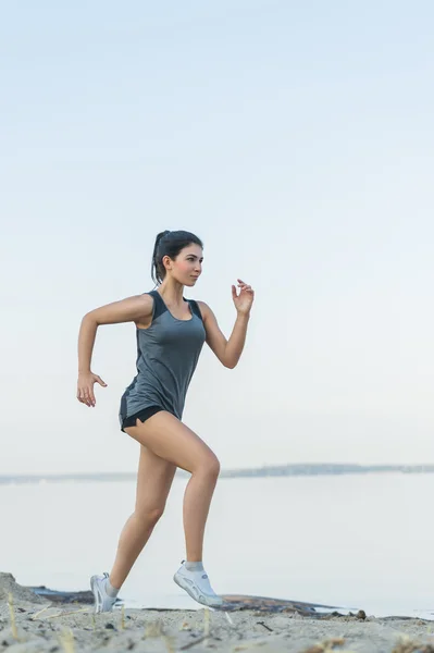 Mujer joven corriendo en la playa —  Fotos de Stock