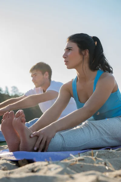 Yoga yaparken genç Çift — Stok fotoğraf