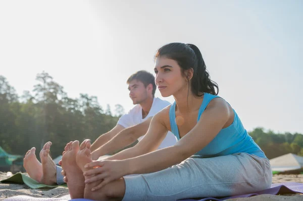 Yoga yaparken genç Çift — Stok fotoğraf