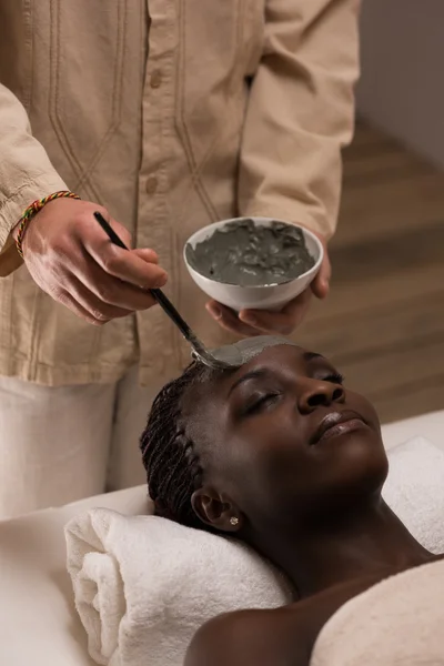 Beautician applying mud mask to woman — Stock Photo, Image