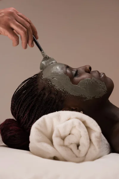 Beautician applying mud mask to woman — Stock Photo, Image