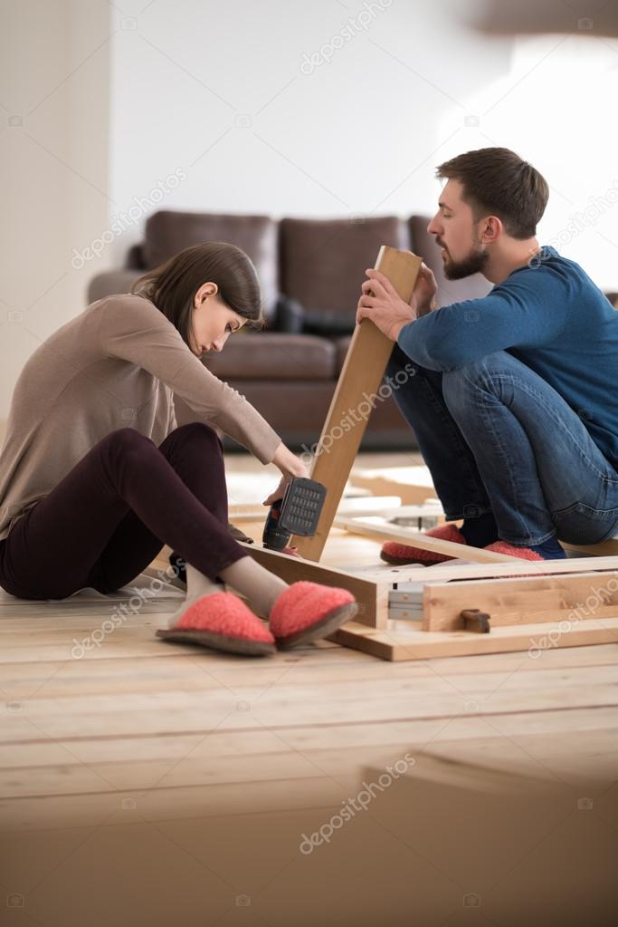 Couple assembling furniture