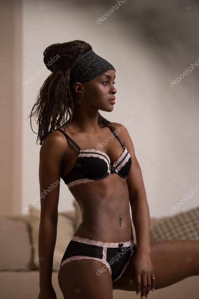 Beautiful black woman in lingerie posing on a bed Photograph by