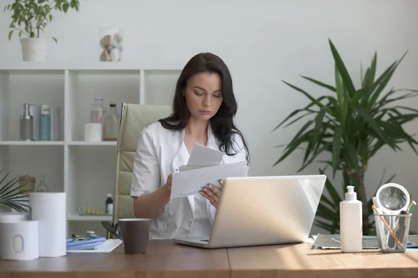 Médico trabajando con resultados de pruebas y computadora — Foto de Stock