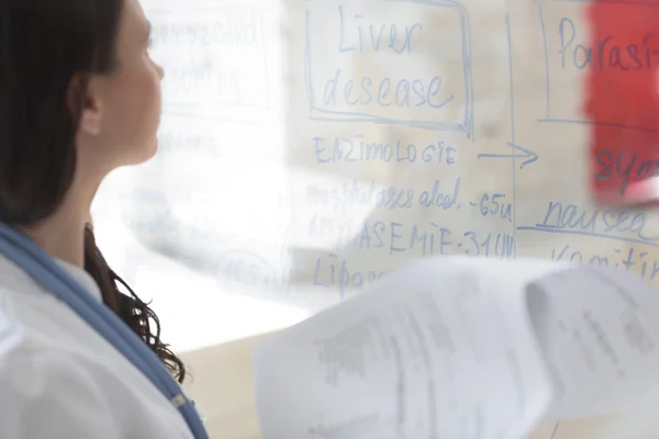 Doctor writing on transparent board — Stock Photo, Image