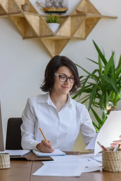 Женщина пишет в офисе — стоковое фото