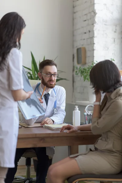 Doctor holding xray and talking to patient — Stock Photo, Image