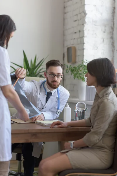 Medico che tiene la radiografia e parla con il paziente — Foto Stock