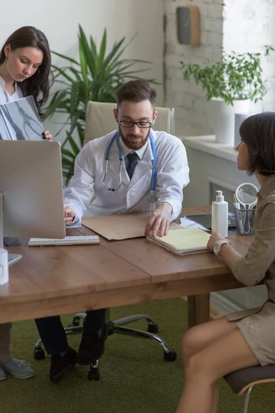 Arzt hält Röntgenbild und spricht mit Patient — Stockfoto