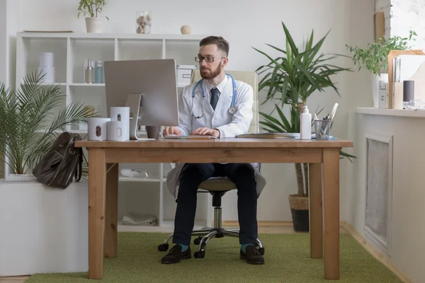 Doctor typing on his computer — Stock Photo, Image
