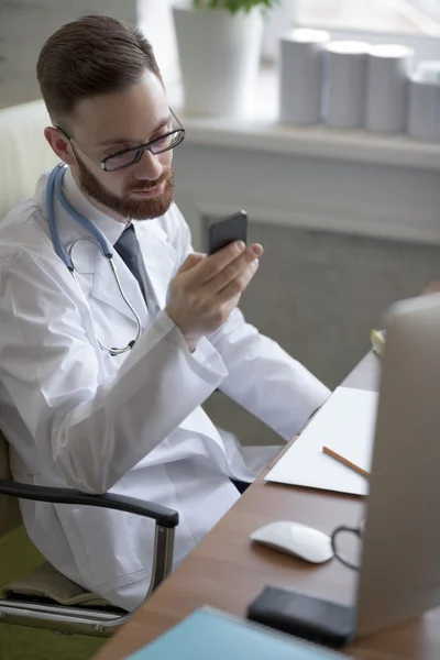 Médico mensagens de texto em seu smartphone — Fotografia de Stock