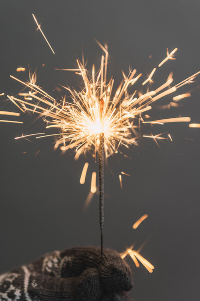 женская рука с рождественской искрой
