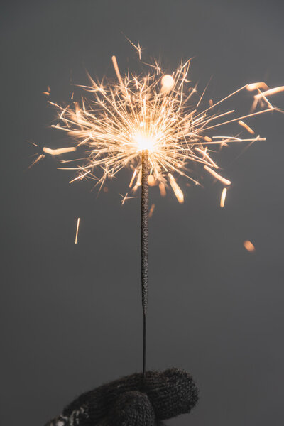 женская рука с рождественской искрой
