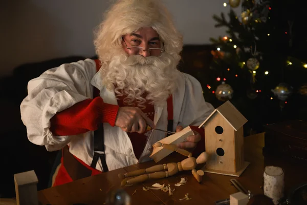 Santa tallando algo de tablón de madera —  Fotos de Stock