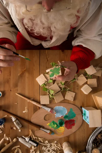 Santa Claus making and painting toys — Stock Photo, Image