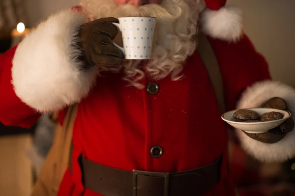 Santa Claus eating cookies and drinking milk — Stock Photo, Image