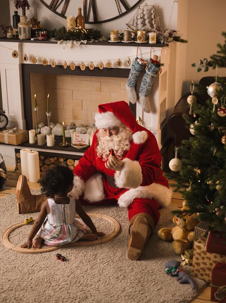 Jultomte med söta afrikansk flicka — Stockfoto