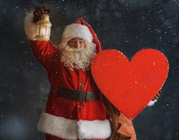 Santa Claus sosteniendo el corazón —  Fotos de Stock