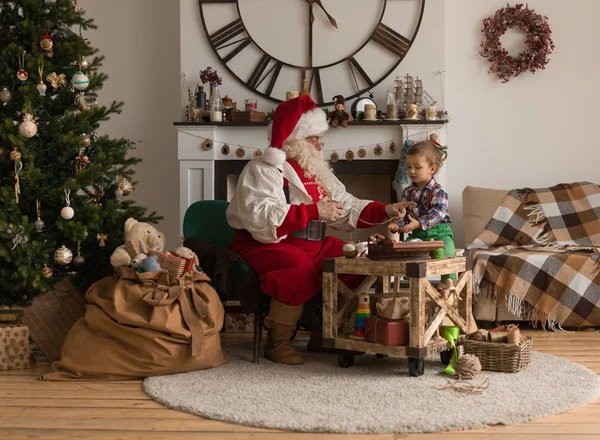 Papai Noel com criança costura juntos — Fotografia de Stock