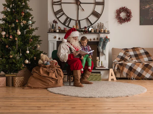 Santa Claus s čtení knihy pro děti — Stock fotografie