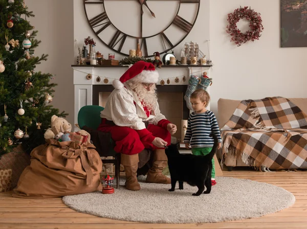 Санта-Клаус с ребенком и кошкой — стоковое фото