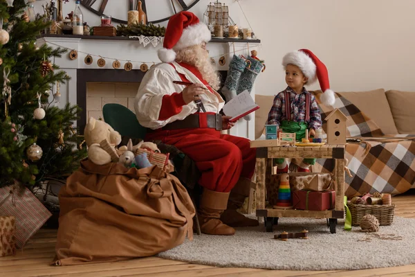 Santa Claus s dítětem dělat hračky — Stock fotografie