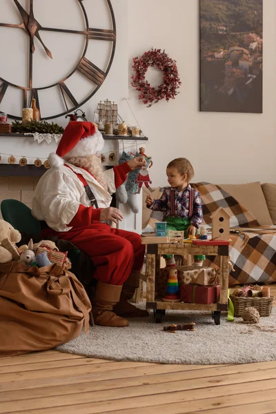 Père Noël avec enfant faisant des jouets — Photo