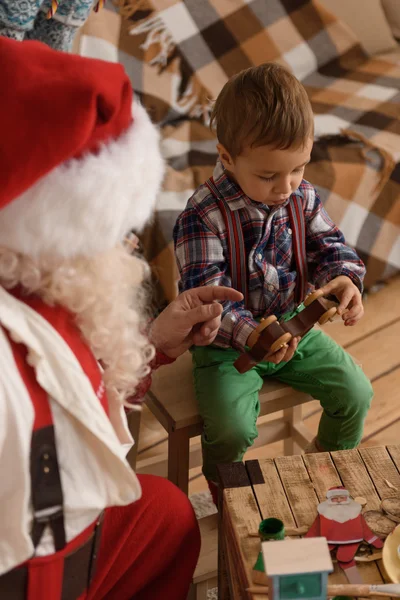 Санта-Клауса з дитиною, роблячи іграшки — стокове фото