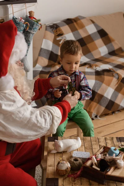 Papai Noel com criança costura juntos — Fotografia de Stock