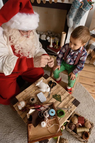 Weihnachtsmann und Kind nähen zusammen — Stockfoto