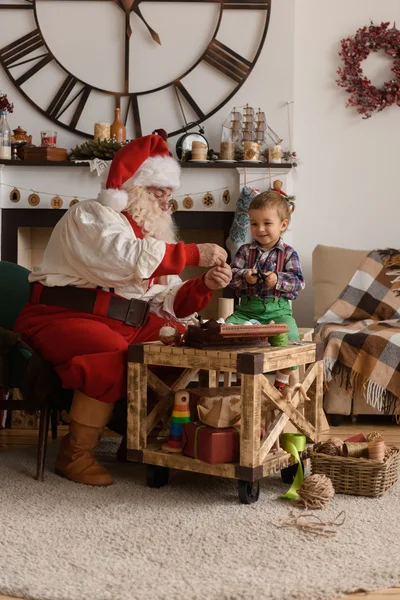 Weihnachtsmann und Kind nähen zusammen — Stockfoto