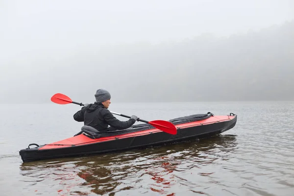 独木舟在水里划桨 手握桨 独木舟运动员 水上运动 在寒冷的秋雾中划船的家伙 积极而极端的休息 — 图库照片